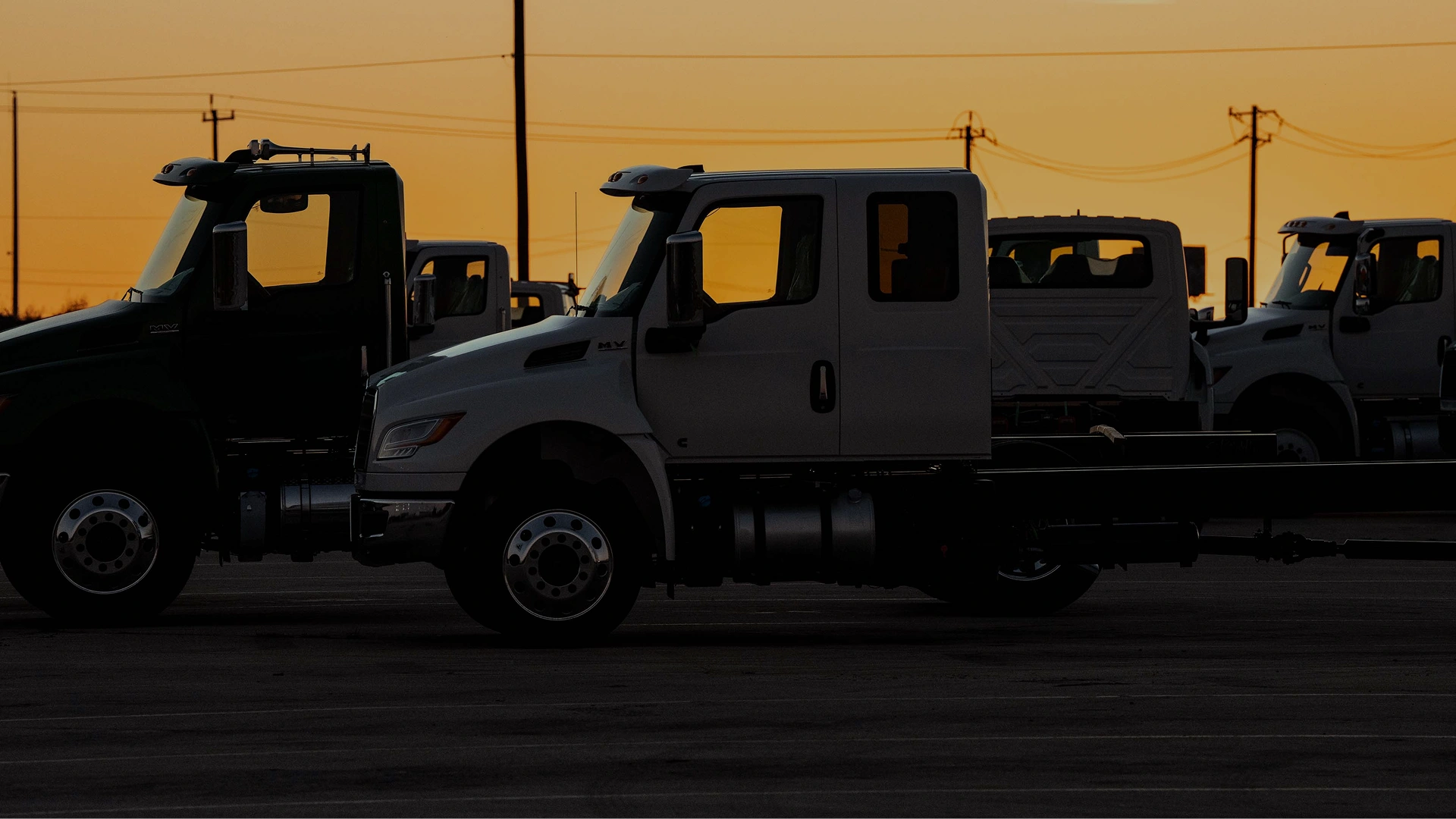 Flota de camiones International estacionados en un patio industrial durante el atardecer